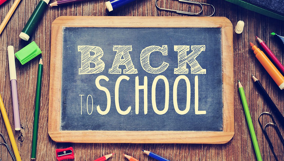 "Back to School" chalkboard on desk with school supplies