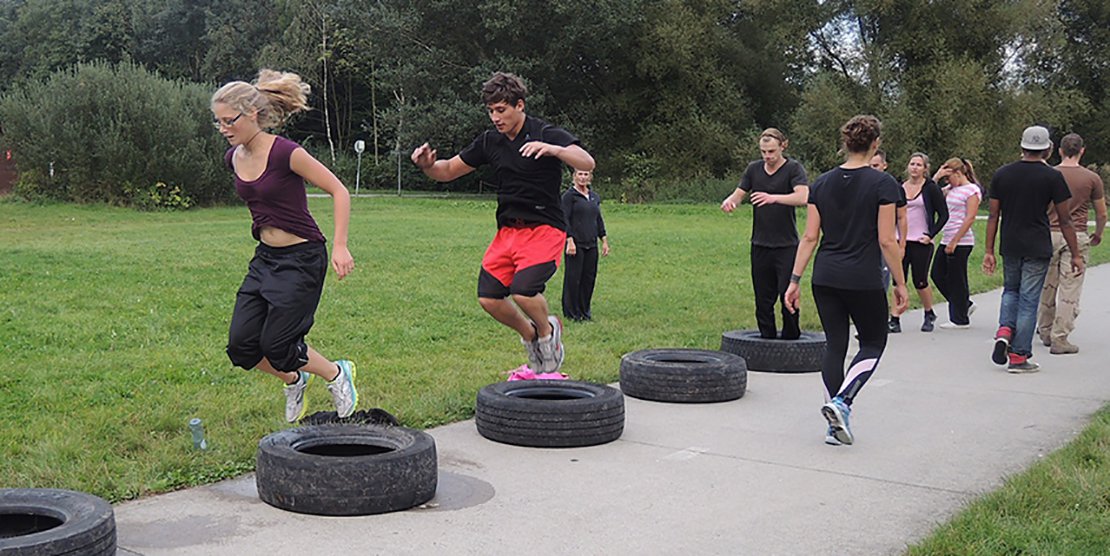 Tire jumping during outdoor fitness boot camp event