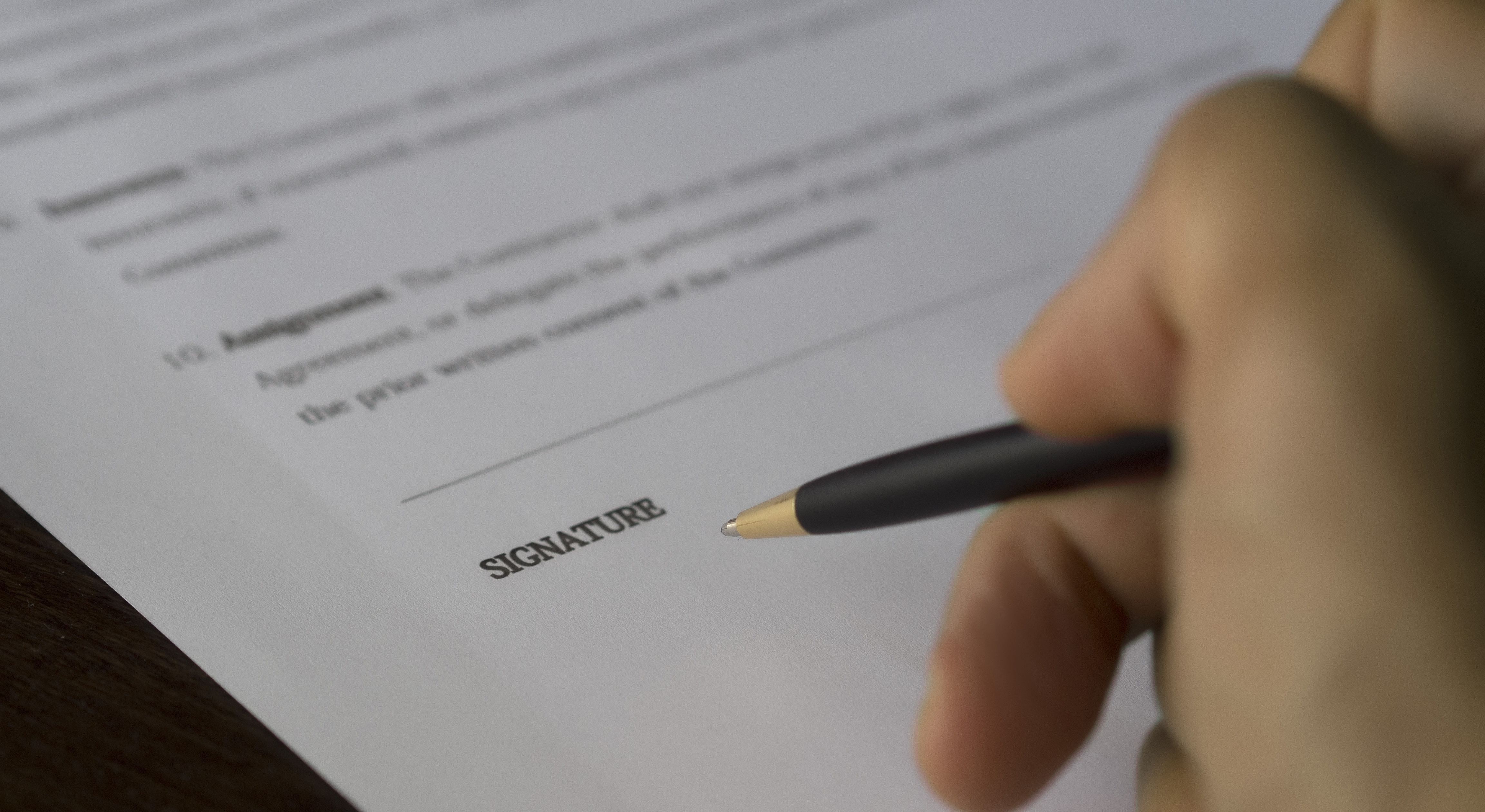membership contract signature with pen on paper