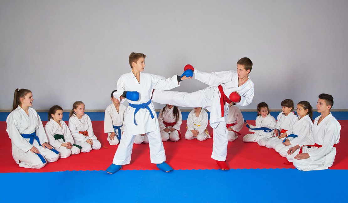 Two boys sparring in martial arts class