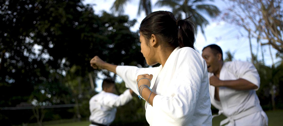 Girl practices punch at martial arts outdoor summer camp