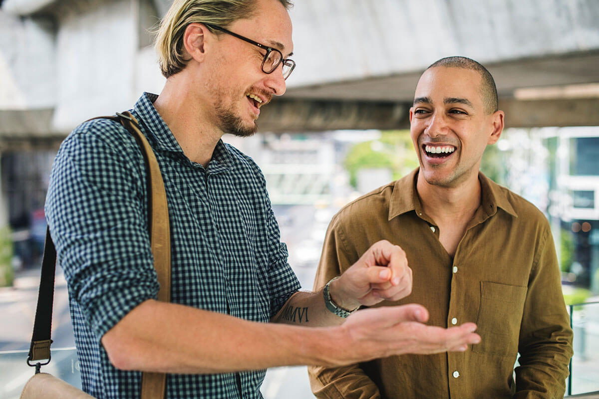 Two smiling colleagues practicing a genuine membership sales pitch